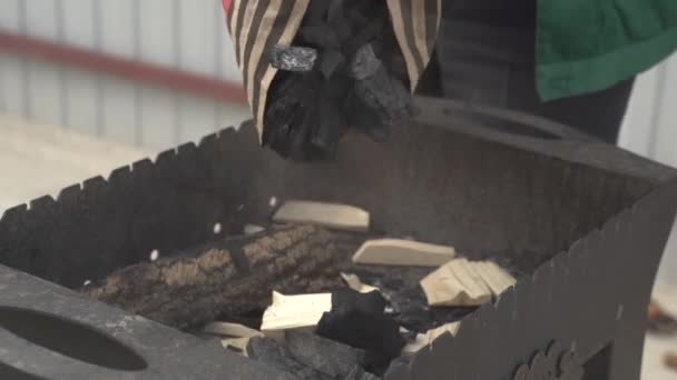 Άνθρωπος Ρίχνει Κάρβουνα Από Ένα Πακέτο Ένα Brazier Για Κάνει — Αρχείο Βίντεο