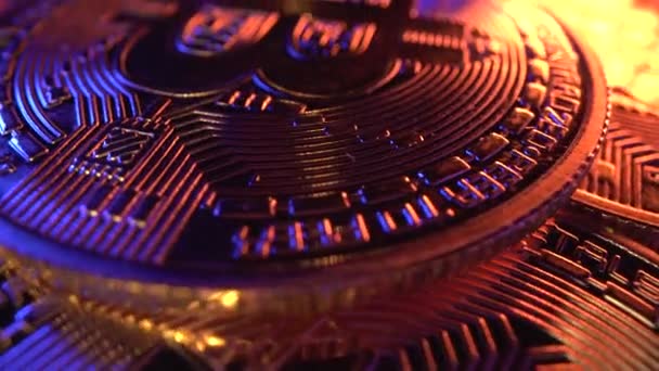 Bitcoin BTC rotieren im goldenen und blauen Licht. Makroaufnahme von Laowa 24mm. Währung. Viele Münzen vor der Halbierung auf dem Tisch — Stockvideo