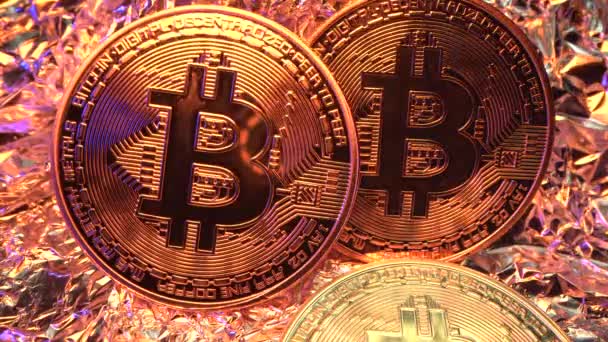 Drie gouden Bit Coin BTC liggen op tafel. Lichtflits op de valuta. Geweldige Macro shot van LAOWA 24 mm. De helft. BitCOIN. 4K — Stockvideo