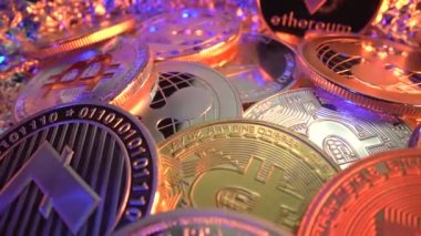 Birçok kripto bozuk para bit BTC, Etherium ETH, Litecoin ZCash ZEC XRP ve masanın üzerinde altın arkaplan ve mavi ışık ile dönen diğerleri, makro çekim kapatın