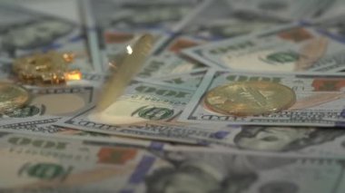 Altın Bitcoin BTC, 100 dolarlık banknotlar ve diğer altın paralarla birlikte süper yavaş çekimde masada döner. Yarı yarıya. Şifreli para masada.