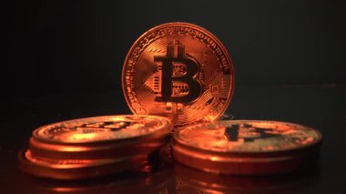 Siyah arka planda 5 sikke BITCOIN BTC. Altın ışık, paraları karanlıktan aydınlatır. Yakın çekim. Yarı yarıya. Şifreli para birimi