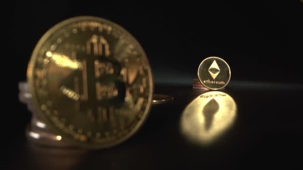 Bitcoin BTC e Etherium ETH refletem sobre a mesa com fundo preto. O foco muda de uma moeda criptografada para outra. Nova moeda. Metade — Vídeo de Stock