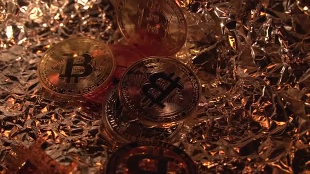Мани вручають золоту крипто-монету Bitcoin BTC на іншу. Камера обертається. Багато монет у рамці. Золотий фон. Половина монета. — стокове відео