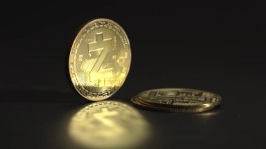 İnsanlar şifreli paraları birbirinin üstüne koyuyorlardı. Ön planda yansıması olan altın Zcash altın sikkesi ve inanılmaz altın ışığı ve siyah arkaplan.