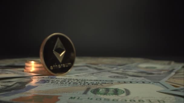 Χρυσό Crypto χρήματα Etherium ETH διαμονή περιβάλλεται από εκατό δολάρια ΗΠΑ. Κάμερα κινείται αργά σε προοπτική νόμισμα και πέρασε από. Κοντινό πλάνο του Μακρο. Βίντεο 4K — Αρχείο Βίντεο
