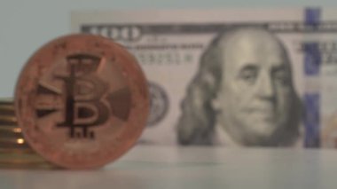Ön planda geleceğin BITCOIN BTC 'sinin bronz madeni parası ve arka planda da 100 Amerikan doları. Şifreli paradan USD 'ye odaklan. Makro yakın çekim. Yarı yarıya. 4K video.