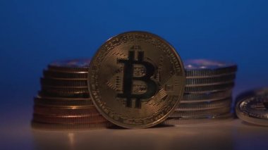 Bitcoin. Şifreli para birimi Altın Bitcoin, BTC, Bit Coin. Bitcoin paralarının makro atışı başka bir altın sikkeyle değiştirildi. Kademe mavi arka plan. Engelleme teknolojisi, bitcoin madencilik konsepti. 4K