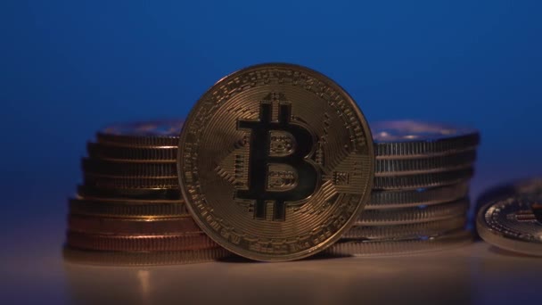 Bitcoin. Monnaie cryptée Bitcoin or, BTC, Bit Coin. Macro shot de pièces Bitcoin tourné avec une autre pièces d'or. Fond bleu dégradé. Technologie blockchain, Bitcoin concept minier. 4K — Video
