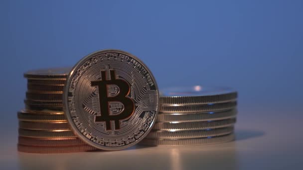 Tecnología Blockchain, plata moneda criptográfica más popular Bitcoin BTC está girando en el sentido de las agujas del reloj en la superficie del reflejo con otras monedas de oro. Fondo azul degradado. Tecnología de cadena de bloques. Reducir a la mitad — Vídeo de stock