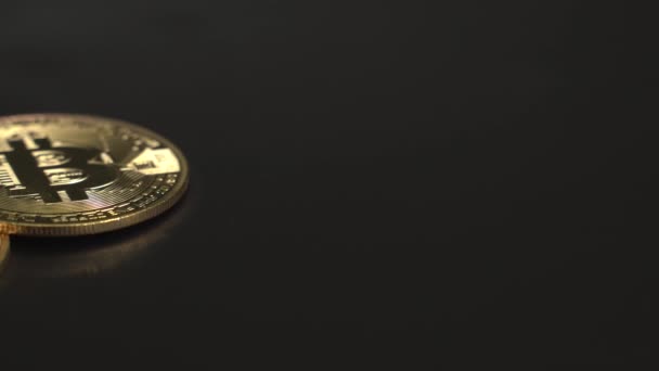 3 bitcoin emas di permukaan hitam. Panorama yang indah dari kanan ke kiri. Setengah Bitcoin BTC. 4K rekaman. — Stok Video