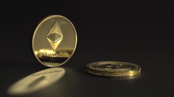 Emas sangat populer kriptokoin Etherium ETH di atas meja hitam dengan refleksi bagus di permukaan. Orang kulit putih menempatkan cryptocurrency satu di atas yang lain. 4K rekaman. — Stok Video