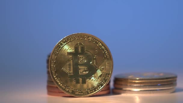 Oro Bitcoin BTC girar sobre la mesa blanca rodeada de otras monedas criptográficas con hermoso fondo azul. Reducir a la mitad. Imágenes de 4K. Primer plano — Vídeo de stock