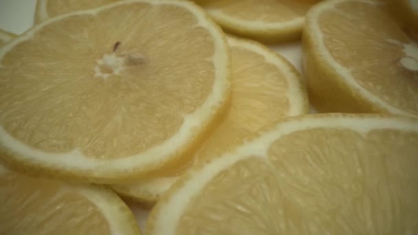 Limón con rodajas rotar en plato blanco. Macro comida disparada desde LAOWA — Vídeo de stock