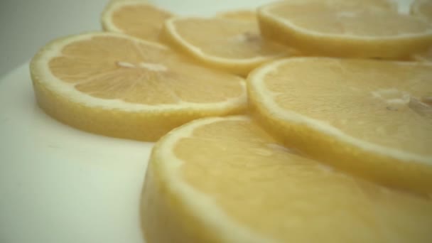Gesneden citroenvruchten verse achtergrond op witte plaat. — Stockvideo