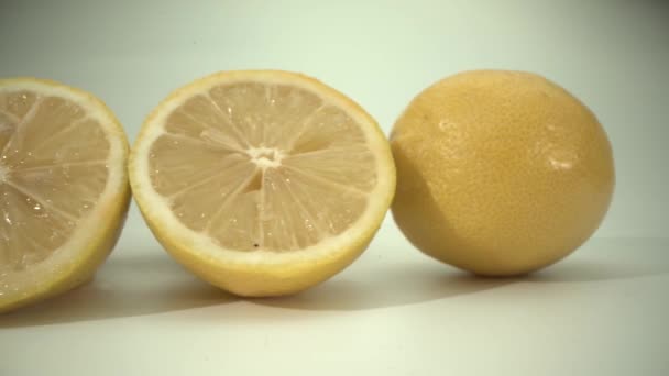 Beyaz bir yüzeyde taze dilimlenmiş limon dilimleri. Yaz havası — Stok video