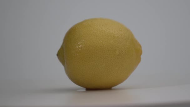 Fresh yellow limon rotate on white surface. Close-up shot. White background. 4k shot — Stock Video