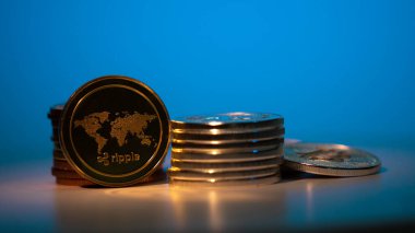 Masada altın dalgalı XRP madeni para ve diğer birçok kripto madeni para ve mavi arkaplan