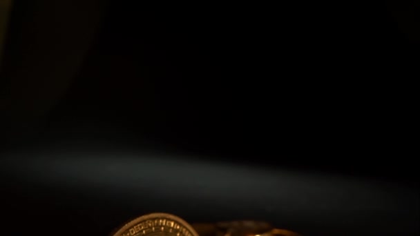 A luz de bronze ilumina várias moedas criptografadas ETHERIUM ETH na superfície preta — Vídeo de Stock