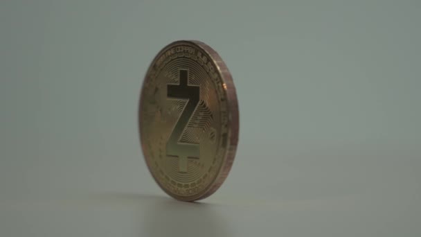 Dinheiro virtual moeda de ouro Zcash zec girar lentamente sobre a superfície branca . — Vídeo de Stock