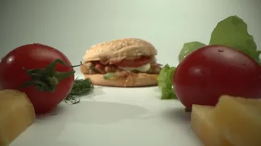 Kamera domatesleri, peyniri ve otları geçip lezzetli bir hamburgere geçiyor. Taze yemek.
