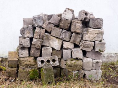 Beton bir arka planda eski gri tuğla yığını
