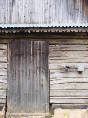 Door to an old aged barn in a village made of their wooden logs 