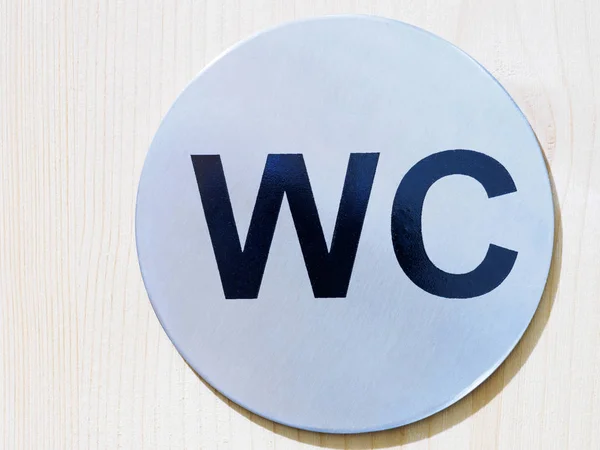 Rundes graues Toiletten-WC-Schild auf Holzgrund — Stockfoto