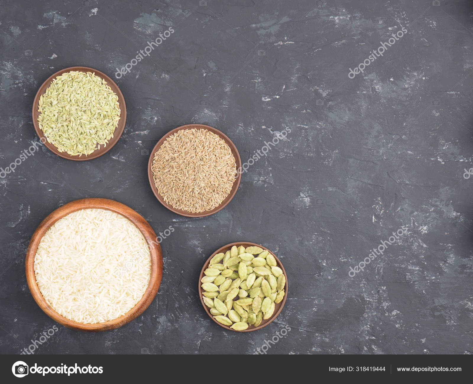 Rice, green cardamom, cumin, fennel on black concrete background Stock