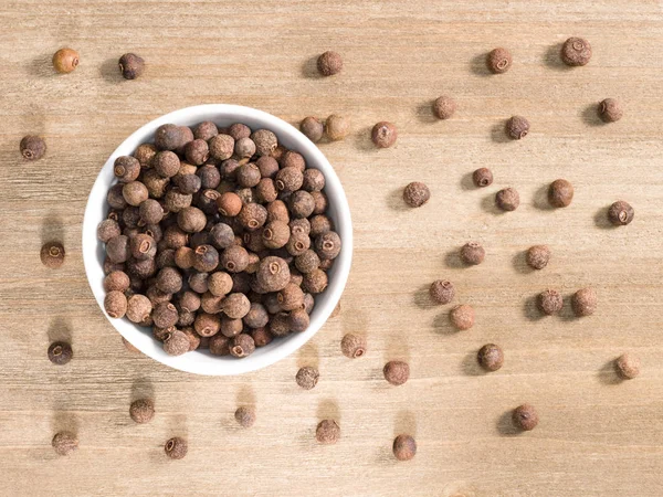 Allspice em tigela branca em um fundo de madeira marrom. Cuis indianos — Fotografia de Stock