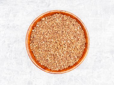 Karabuğday, beyaz çimento arka planında bambu kasesinde inliyor.. 