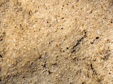 Küçük taşlı, eski, beton sarısından bir arka plan. Tuap