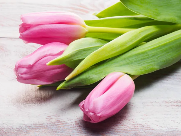 Tres tulipanes rosados sobre un fondo de madera. Día de San Valentín y Wo —  Fotos de Stock