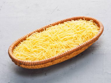 Small spaghetti in wooden bowl on gray concrete background. Diet