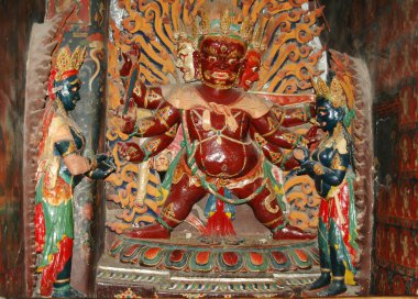Kahverengi Tibet İlahı heykeli. Altı kollu altın bir taç içinde. 
