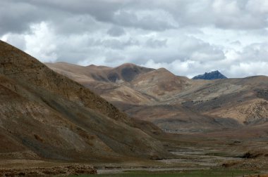 Bulutlu gökyüzüne karşı Tibet dağları