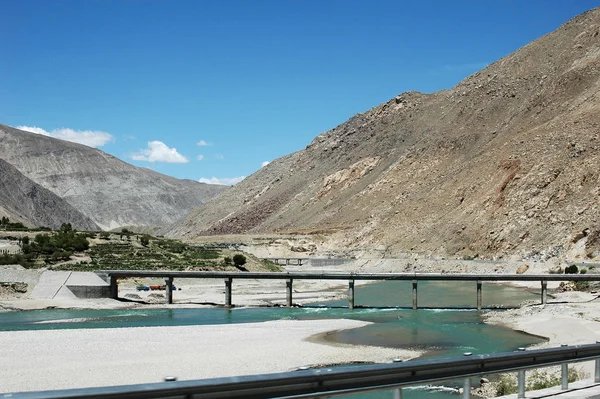 Tibetská krajina s řekou a mostem — Stock fotografie