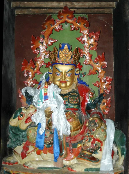 Estátua antiga de uma divindade tibetana cor dourada em um ani mítico — Fotografia de Stock