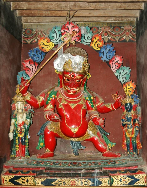 Estatua de deidad tibetana roja en un monasterio en el Tíbet — Foto de Stock