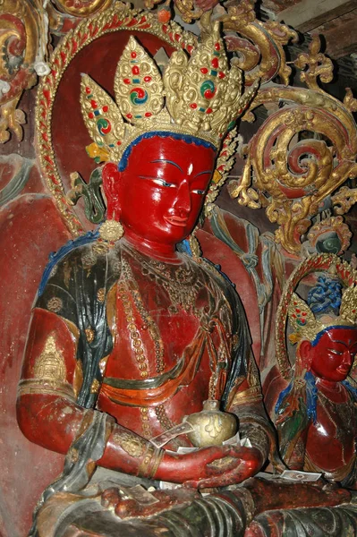 Antigua estatua sagrada de Buda con una cara roja en una corona en una Tib — Foto de Stock