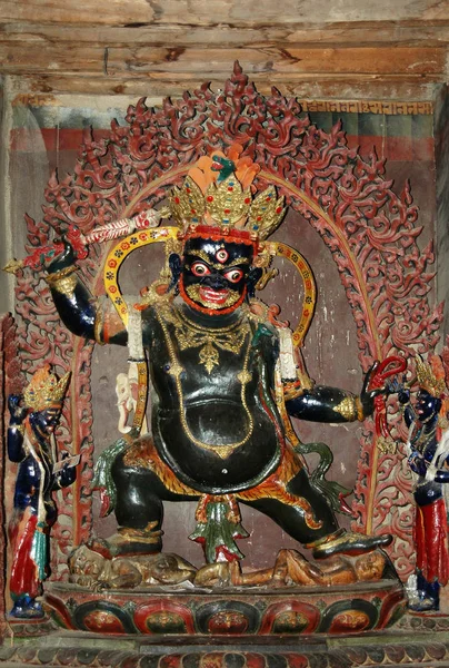 Tibet 'teki bir manastırda siyah bir tanrının antik kutsal heykeli.