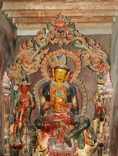 Antigua estatua de una deidad tibetana con un cuerpo amarillo en un monasterio —  Fotos de Stock