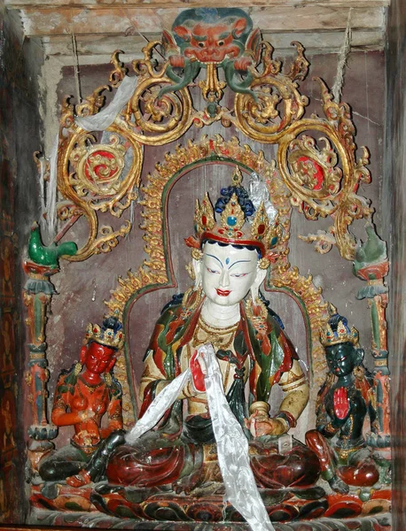Egy ősi fehér tibeti istenség szobor lótuszban pózol egy kolostorban. — Stock Fotó
