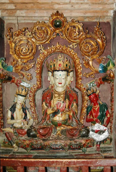 Antigua estatua de una deidad tibetana con tres cabezas de colo blanco —  Fotos de Stock