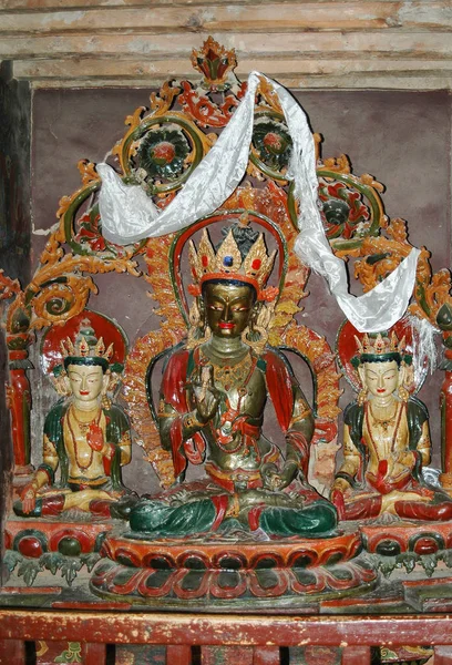 Ancient statue of a bronze-colored Tibetan deity in a lotus pose — 스톡 사진