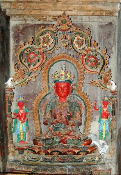 Ένα αρχαίο άγαλμα θιβετιανής θεότητας με ένα κόκκινο πρόσωπο σε ένα μοναστήρι. — Φωτογραφία Αρχείου
