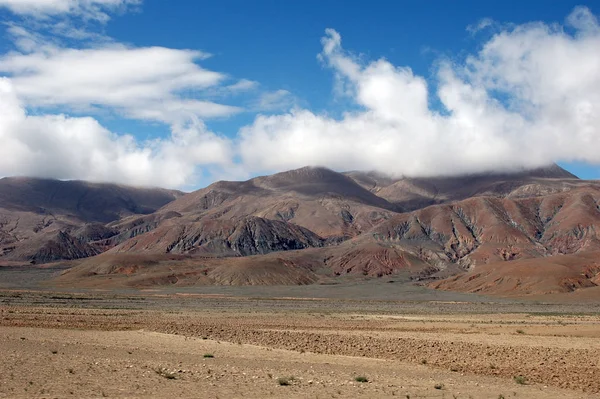 Bruine bergen, blauwe lucht en wolken in tibet — Stockfoto