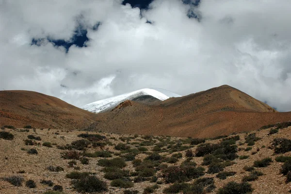 Tibetische Landschaft mit Sand, Gras, braunen Hügeln, schneebedeckter Erbse — Stockfoto