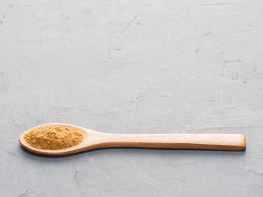 Spice masala in wooden spoon on gray concrete background. Indian