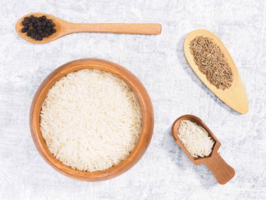 Kahverengi ahşap kase içinde Hint uzun tahıllı Basmati pilavı, kimyon.